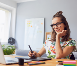 woman with eyeglasses using a pen tab