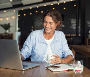 woman holding a cup of coffee while working